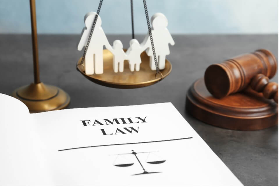 Block figure of a family on a justice scale with a gavel and paper that says 'Family Law'
